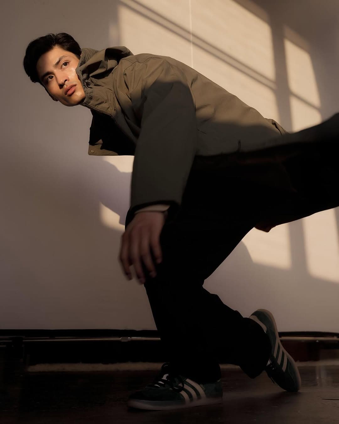 Christian Pumpelly fashion editorial in olive jacket with dramatic lighting